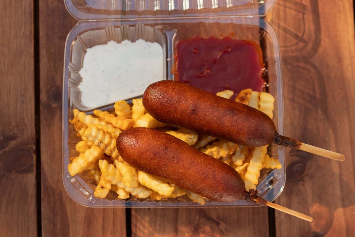 Corn dog meal with fries and a drink