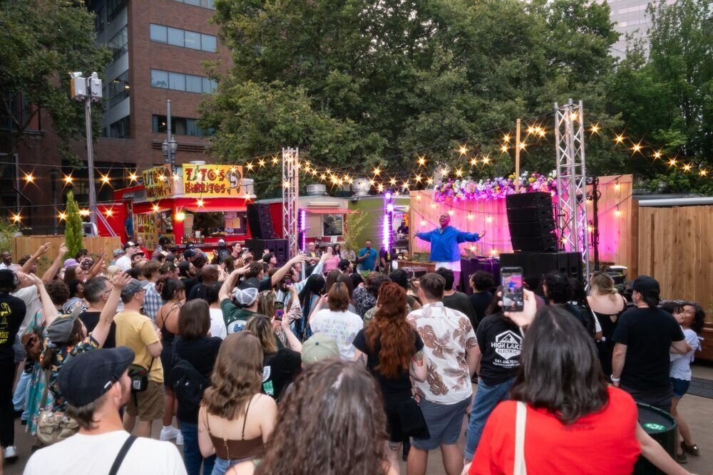 A crowd enjoying live music at the Midtown Beer Garden opening celebration